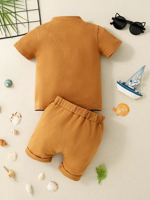 Brown baby polo shirt and shorts set with cuffed hems.