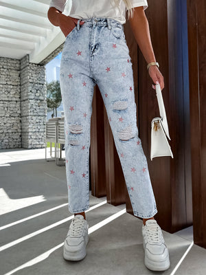 Light acid wash distressed jeans with pink star embroidery and ripped details.