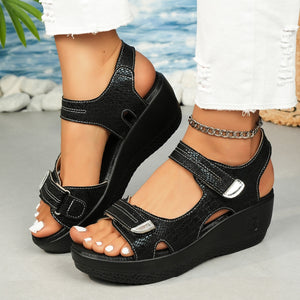 Black textured wedge sandals with adjustable straps and contrast stitching.