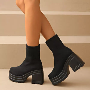 Black sock ankle boots with round toe and chunky platform heel.