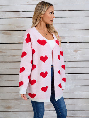 Pink acrylic cardigan with red heart intarsia pattern, open front, long sleeves.