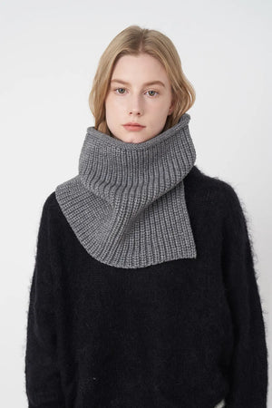 Ribbed neck warmer in dark gray with extended panel, worn over a black sweater.