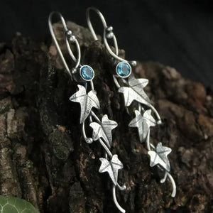 Sky blue gemstone and silver ivy vine drop earrings with intricate leaf detail.