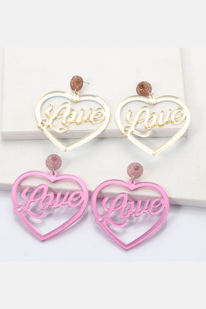 Glitter studded acrylic heart earrings with "Love" cutout in pink and gold.