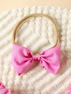 Pink floral baby bow headband with red flower accents.