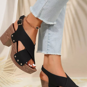 Black crisscross block heel sandals with stud details and wooden platform.