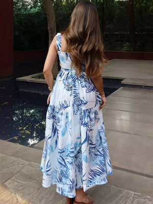 Maxi dress with blue tropical leaf print, tiered skirt, and lace trim.