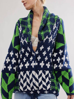 Geometric patchwork knit cardigan in navy, green, and white with a shawl collar and button closure.