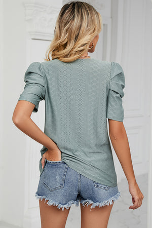 Perforated puff sleeve top in light green with textured diamond pattern.