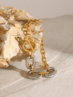 Two-tone chain link bracelet with toggle closure, gold and silver oval links.