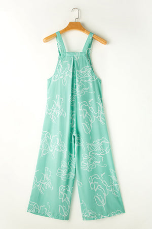 Turquoise botanical print wide-leg jumpsuit with wide straps and pleats.