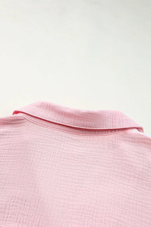 Pink cotton casual shirt with textured fabric and button-down collar detail.