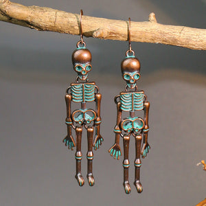 Skeleton silhouette drop earrings in antique bronze with teal accents.