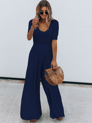 Dark blue textured wide-leg jumpsuit with subtle waist and v-neckline.