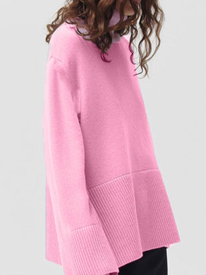 Pink ribbed turtleneck sweater with flared sleeves and a ribbed hem.