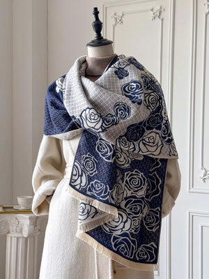 Elegant floral pattern scarf in blue and white with fringed edges.