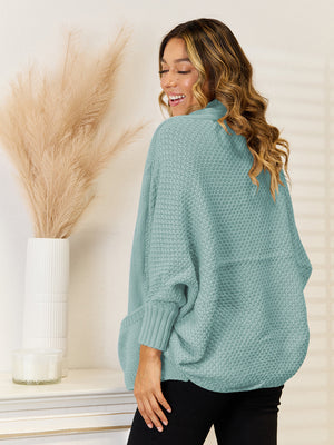 Teal acrylic knit cocoon cardigan with pockets and cuffed sleeves.