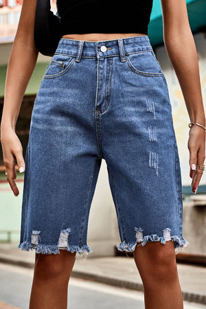 Medium wash denim bermuda shorts with frayed hem and distressed details.