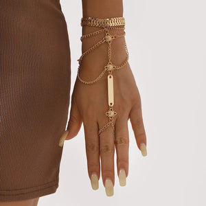 Gold multi-layered chain bracelet with bar detail and ring attachment.