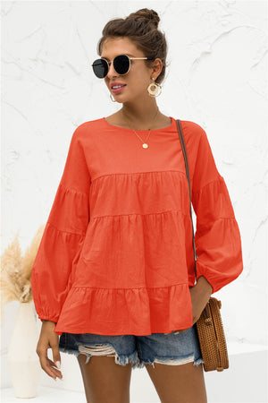 Orange tiered peasant blouse with ruffled balloon sleeves and crew neck.