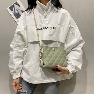 Green quilted crossbody bag with diamond pattern and gold chain strap.