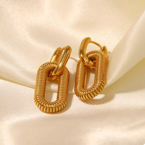 Gold sculptural link drop earrings with ribbed texture detail.