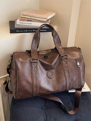 Brown pu leather duffel bag with zippered pocket and adjustable strap.