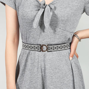 Elasticated belt with black and white pattern and gold circle buckle
