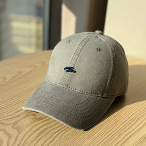 Distressed dark gray cotton baseball hat with curved brim and navy embroidered logo.