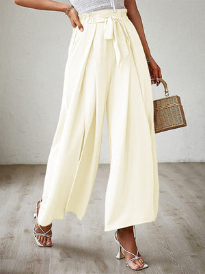 Pleated palazzo pants in pastel yellow with sash and side slit, wide leg, high waist.