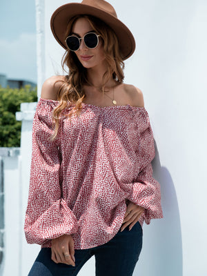 Off-the-shoulder blouson top in deep red spotted print with balloon sleeves.