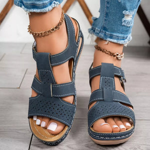 Blue perforated mid-wedge sandals with adjustable straps and white stitching.
