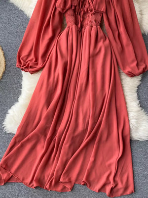 Maternity dress in watermelon red with square neck, ruffled detail, smocked bodice, and balloon sleeves.