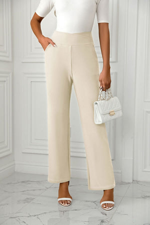 Beige wide-leg trousers with a sculpted waist and side pockets.