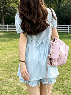 Light blue ruffled two-piece set with adjustable ties and cinched waist.