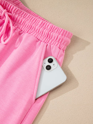 Pink cotton drawstring bikini bottoms with elastic waistband and pocket detail.