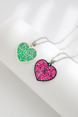 Spooky season heart necklaces in green and pink with glitter spiderwebs.