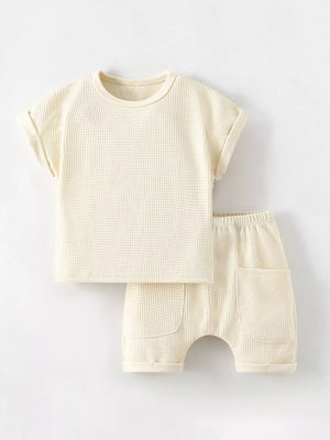 Beige waffle knit toddler tee and shorts set with rolled cuffs and pockets.