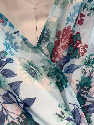 Light blue floral wrap mini dress with V-neck and ruffle hem detail.