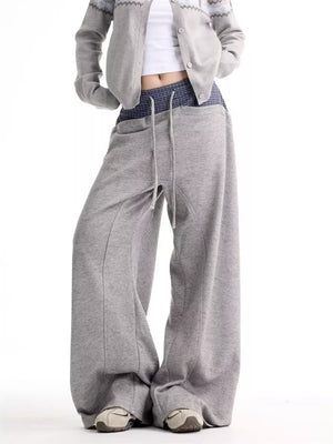 Grey wide-leg sweatpants with drawstring and pockets, styled with a cropped cardigan.