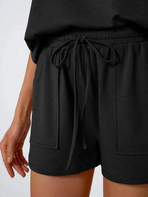 Black drawstring shorts with elastic waist and patch pockets.