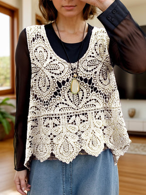 Cream lace overlay cropped vest with intricate floral pattern and scalloped hem.