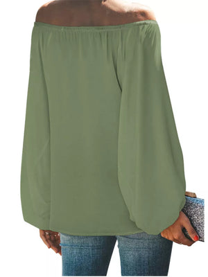 Green off-shoulder maternity blouse with balloon sleeves, styled with jeans and a clutch.