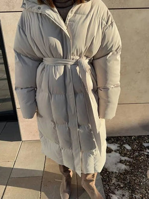Ivory white padded trench coat with tie belt and hood, long sleeves, full length.