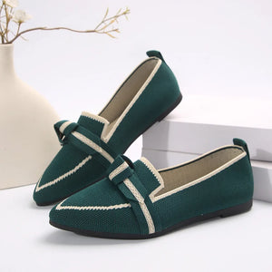Dark green knit bow loafers with pointed toe and cream trim.