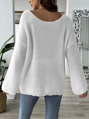 White slouchy boatneck knit sweater with wide sleeves and ribbed texture.