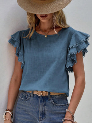 Dusty Blue blouse with ruffle sleeves and pom-pom trim.