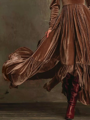 Dark brown velvet maxi dress with voluminous sleeves and ruffled hem.