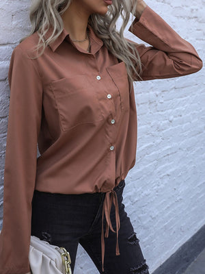 Caramel drawstring waist utility shirt with buttoned chest pockets and long sleeves.