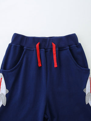 Navy cotton toddler pants with shark applique and red drawstring detail.